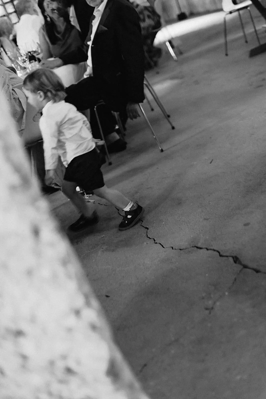 A child walking across the stone floor past the tables