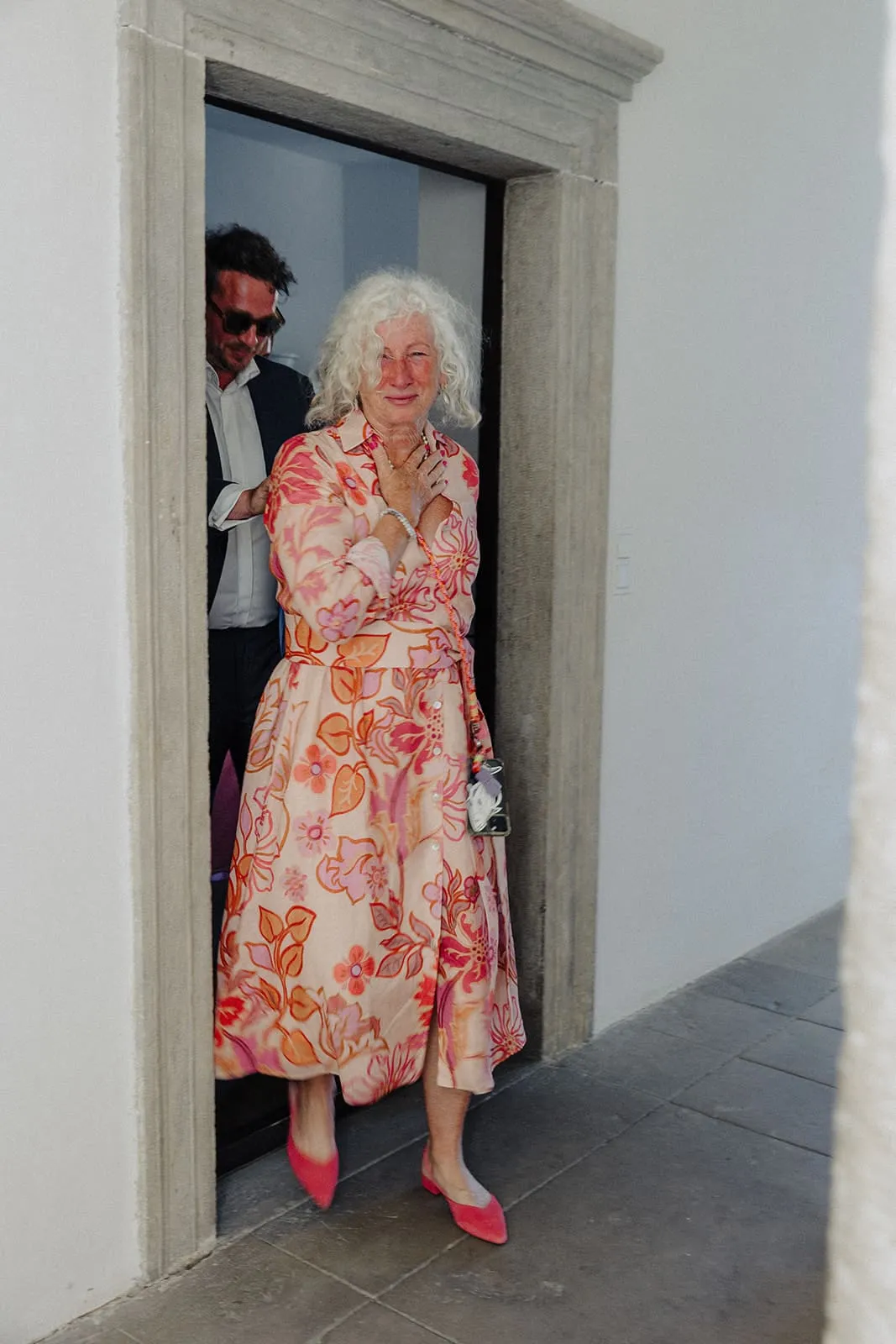 A guest in a floral dress stepping through the stone doorway