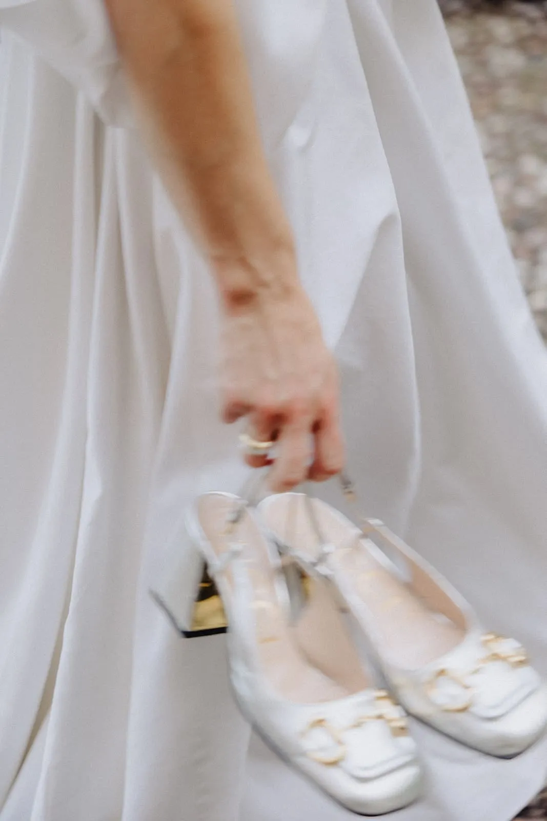 The bride carrying her shoes in her hand, the dress in motion