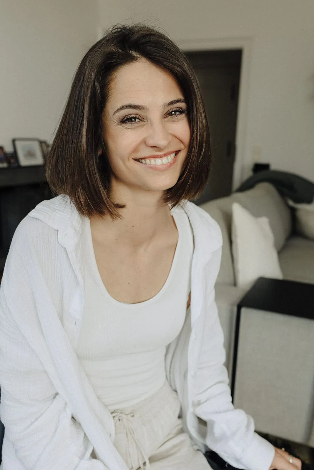 The bride smiling straight into the camera in her living room