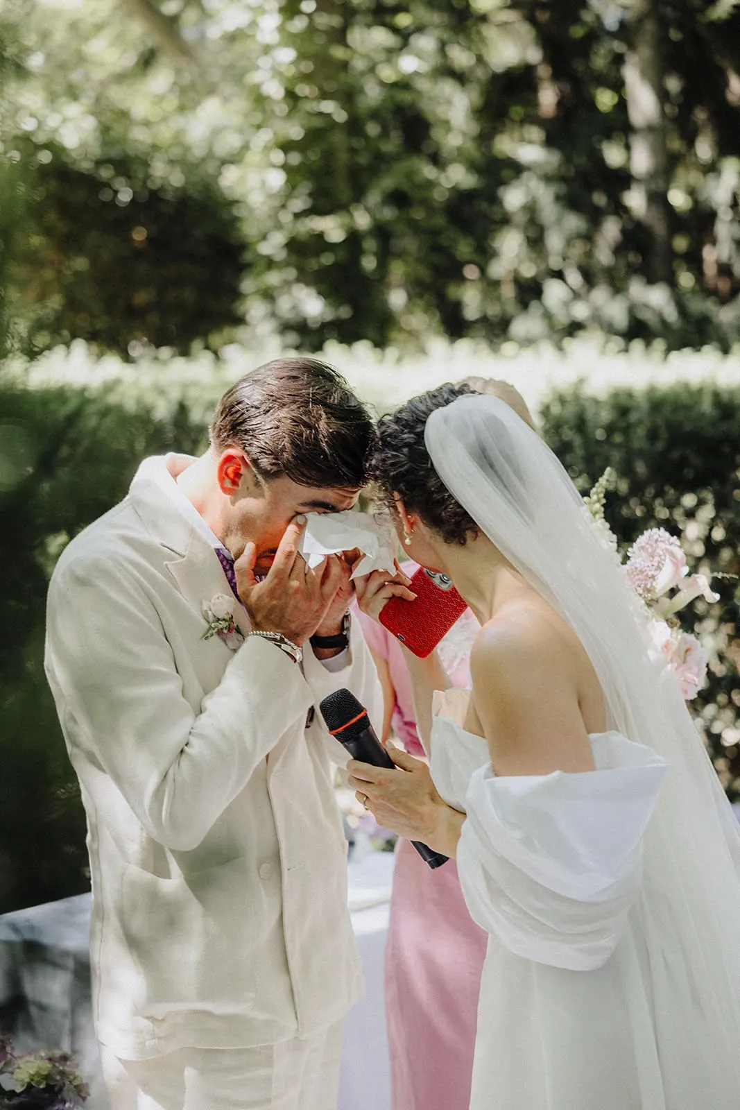 The groom wiping his eyes during the ceremony, the bride beside him